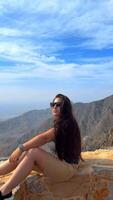 Happy asian woman tourist raise hands enjoys breathing fresh air high in cloudy mountains at cold weather. Young hiker at amazing hazy background of mountain landscape standing back. Active sport. video