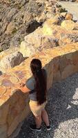 Happy asian woman tourist raise hands enjoys breathing fresh air high in cloudy mountains at cold weather. Young hiker at amazing hazy background of mountain landscape standing back. Active sport. video