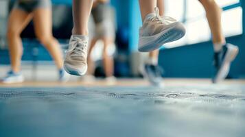 A closeup of a persons feet as they perform a series of jumps and squats in a boutique fitness class focused on plyometrics photo