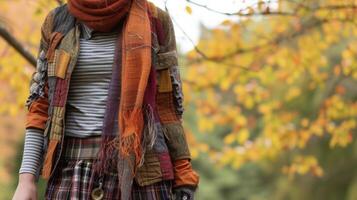 labor de retazos capas un labor de retazos chaqueta desgastado terminado un a rayas camiseta y tartán falda coronado apagado con un tejer bufanda y tobillo botas. Perfecto para un crujiente otoño día errante a través foto