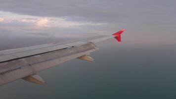 ein Flugzeug Flügel im Flug Über das riesig Weite von das Ozean. oben Aussicht von das Bullauge. Konzept Reise und Tourismus video