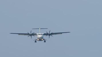 Front view of a turboprop airplane with an unrecognizable livery flying, descending for landing. Twin-engine short-haul regional passenger aircraft. Blue background. video