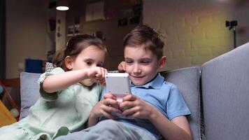 A girl helps tells a boy how to play a game on a hand-held vintage console video