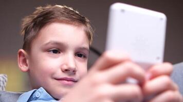 closeup portrait of a boy playing games on an old vintage handheld console video