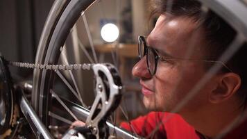 close-up man with glasses fixing his bike at home video