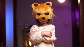 portrait de une fille dans une ours masque des stands avec le sien bras franchi Halloween masque video