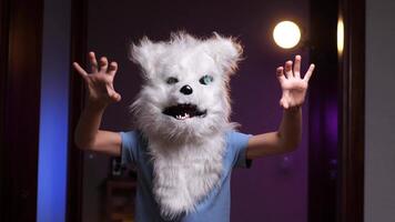 boy in a wolf mask trying to scare with gestures and growls, mask for halloween video