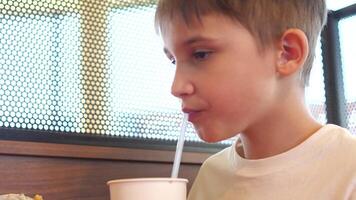 de cerca de un chico Bebiendo soda desde un Paja y comiendo basura comida video