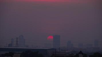 de zon is instelling achter een stad horizon, gieten een warm gouden gloed over- de gebouwen en creëren een silhouet tegen de lucht video