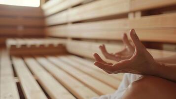 un persona sentado en un de madera banco en un sauna ojos cerrado y manos pags en un meditativo mudra como ellos dejar Vamos de su pensamientos y atención en su aliento. foto