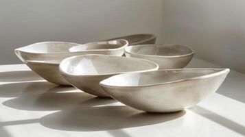 A set of handcarved ceramic dishes each formed from a single block of clay and featuring a smooth shiny finish. photo