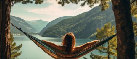 AI generated girl in a hammock against a background of mountains and a lake, rear view Generative AI photo