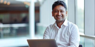 male Hindu businessman using a laptop in the office photo