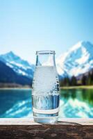 clean drinking water in a bottle against the background of a lake and mountains photo