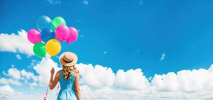 Girl in a dress with balloons and a hat against the sky, rear view banner photo