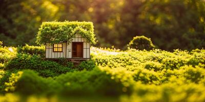 model of a small wooden house with a moss roof on a green blurred background banner photo