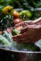 hands wash vegetables splashing water photo