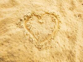 fotografía de dibujar amor en el playa arena en verano foto