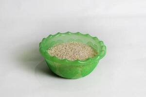 photography of rice in a plastic container on an isolated white background photo