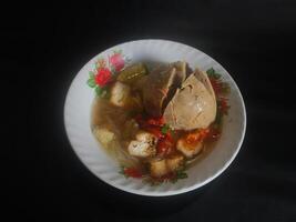 Photography of jumbo meatballs food from Indonesia on a bowl on a black background photo