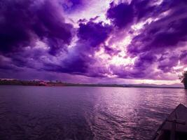 fotografía de el ver de el puesta de sol cielo en el tarde es púrpura en el mar foto