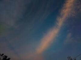 fotografía de un hermosa noche cielo con naranja luz de sol foto