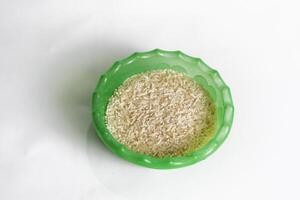 photography of rice in a plastic container on an isolated white background photo
