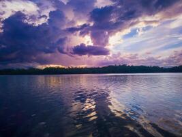 photography of the view of the sunset sky in the afternoon is purple on the sea photo