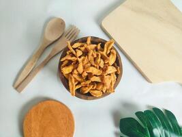 photography of cimi-cimi snack food in a wooden bowl on a white background photo