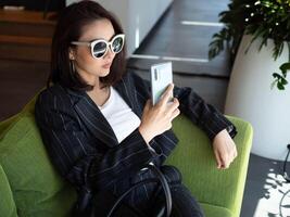 Businesswoman female girl lady person people wear suit sunglasses selfie camera smartphone happy smile technology mobile tablet phone lifestyle top view funny enjoy photo cheerful device themes