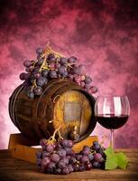 Red wine glass barrel with grapes photo