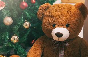 Teddy bear near christmas tree with gifts photo