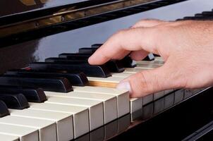 Piano keyboard made of ivory with hands photo