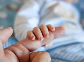 Detail of the fingers of a newborn, especially the nails. Newborn babies have long, sharp nails full of nerve endings. photo