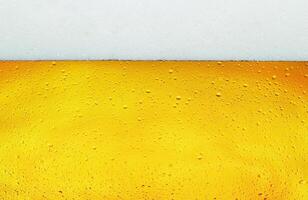 Close up background texture of lager beer with bubbles and froth in glass. photo