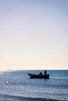 Fisherman boat in silhouette photo