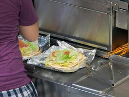 Street food vendor prepares a flat bread photo