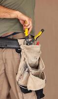 Worker uses tool belt, authentic and real moment. photo