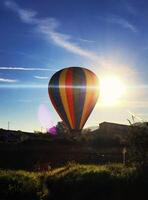 Hot air balloons taking off with sunlight behind photo