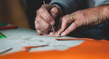 Shoe designer working with leather. photo