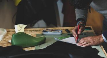 Shoe designer working with leather. photo