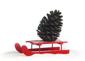 Wooden red sled with brown pine cone photo