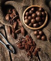 Macadamia, Pecan and Pili nuts on wooden table photo