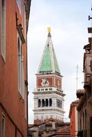 View of the bell tower of San Mark between the houses. photo