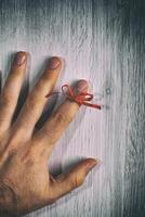 Red String Tied Around a Finger. Memory and Reminder Knot photo