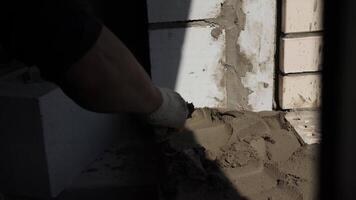 constructor aplica el cemento mortero con un espátula video