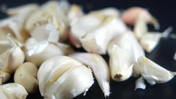 slow motion of garlic drops on a black background, video