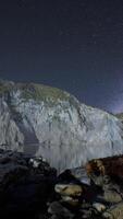 hyperlapse av nattstjärnhimmel med berg och havsstrand i Lofoten norge video