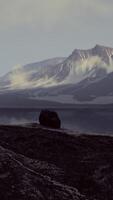 View of a landscape of a Norwegian fjord with a snowy mountain and rocks video