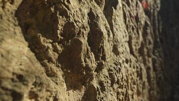 Person walking on close-up rock wall video